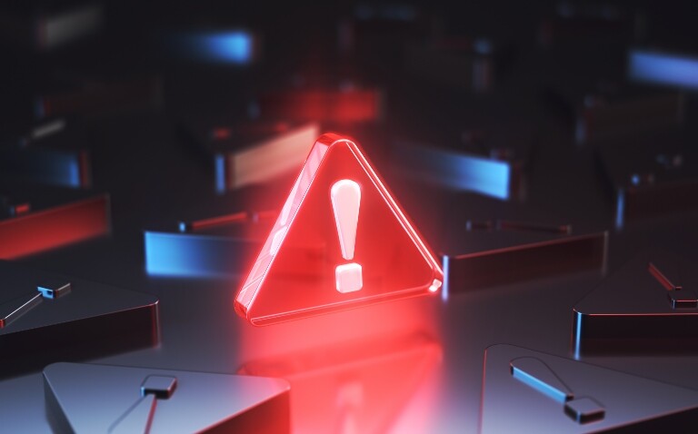 An upright red glowing warning triangle with an exclamation mark in the centre surrounded by black warning triangles lying down to illustrate a new AI-led early warning system for NHS safety issues