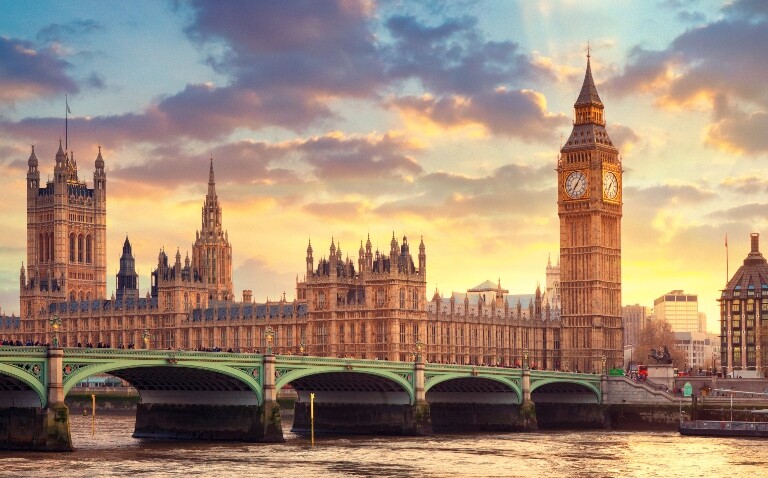 A photograph of Westminster Bridge and the Houses of Parliament building with a sunset behind to illustrate the passing of the assisted dying bill by MPs in England and Wales