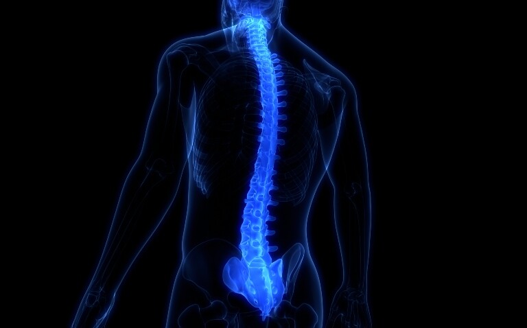 A 3d computer generated drawing of a human body in blue on a black background with a glowing spine and sacroiliac joints to suggest axial spondyloarthritis and illustrate a new BSR guideline