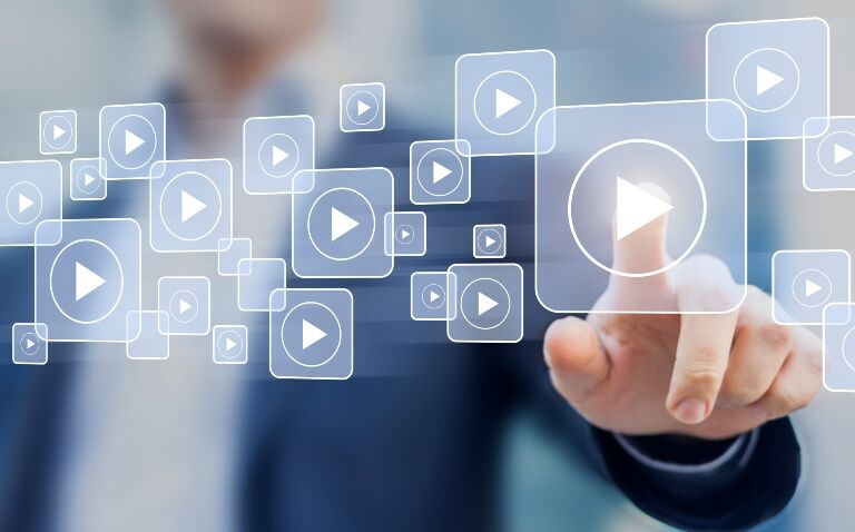 Man presses one of many play buttons suggesting on demand video and the launch of the Clinical Excellence Video Zone to support best practice