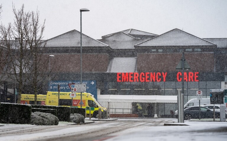 A hospital building in the snow with an ambulance driving past and signs for the emergency department to illustrate a dramatic reduction in hospitalisations from RSV vaccination last winter