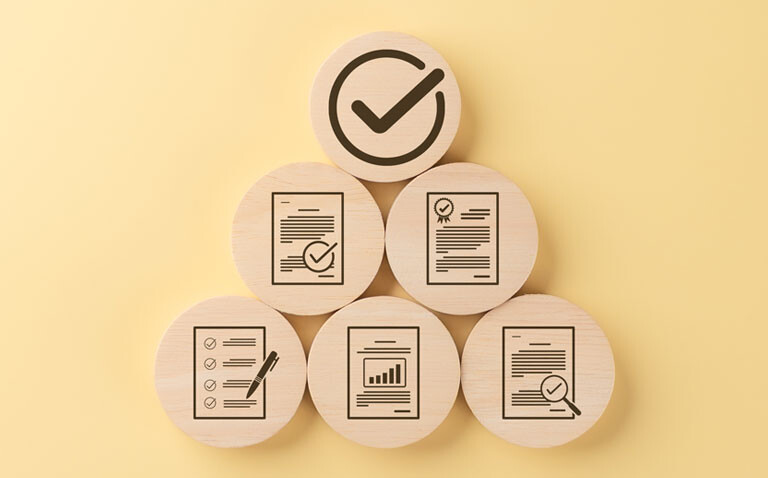 Wooden discs arranged in a pyramid with icons representing checklists