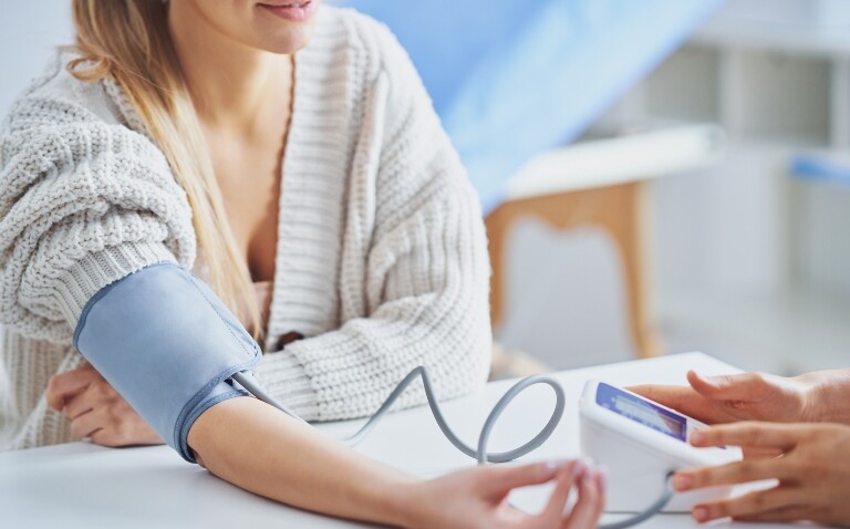 A close up of a woman having her blood pressure checked to illustrate hypertensive pregnancy disorders doubling the long-term risk of dilated cardiomyopathy