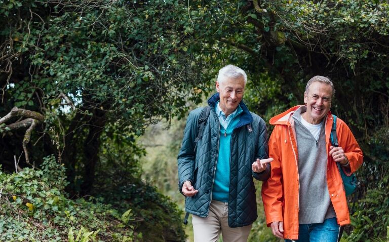 Two older men walking in the woods to improve cardiorespiratory fitness