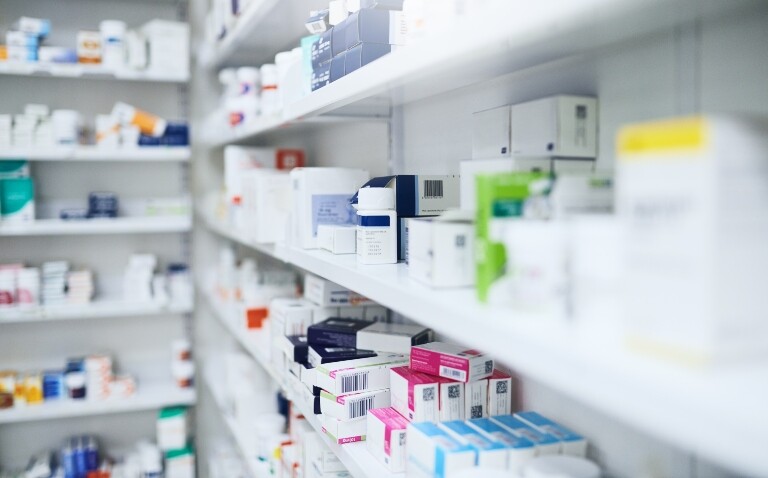 Shelves stocked with boxes and bottles of various medicines in a pharmacy dispensary to illustrate the announcement of England having a single national formulary within two years
