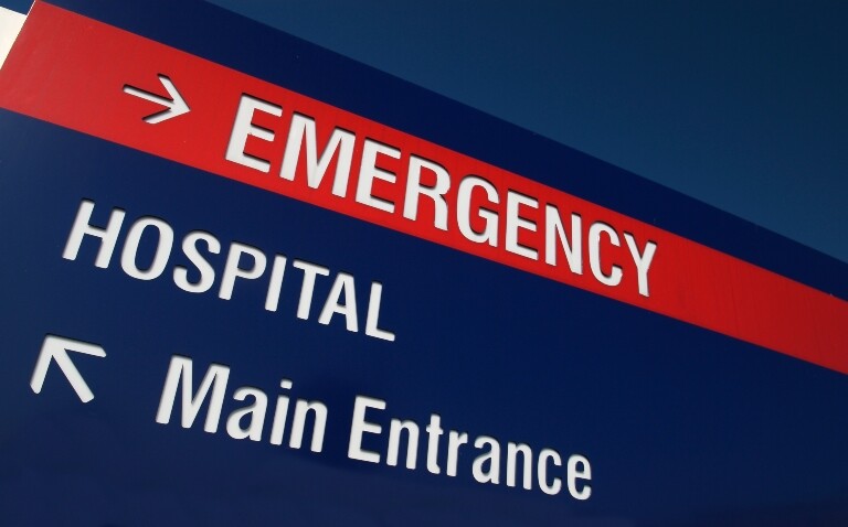 A close up of a navy blue hospital sign with a red stripe at the top saying emergency and an arrow pointing to the right