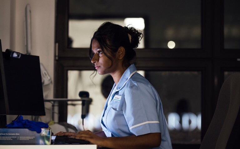 A nurse sat at a computer on a hospital ward at night to illustrate women working night shifts being more likely to have asthma