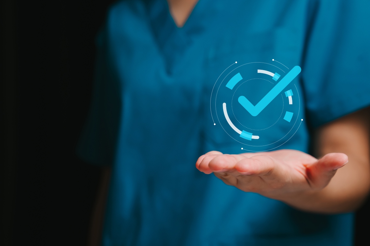 A close-up of a medic wearing scrubs with their hand outstretched and an illustration of a tick in a circle sitting above their palm to illustrate the finding that lutikizumab delivers clinically meaningful improvements in refractory hidradenitis suppurativa