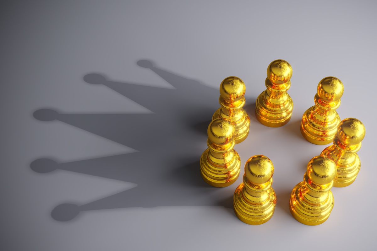 Seven gold coloured chess pawns in a circle making a shadow of a crown on a grey background to represent gold-standard MDT support in breast cancer care with support from Breast Cancer Now
