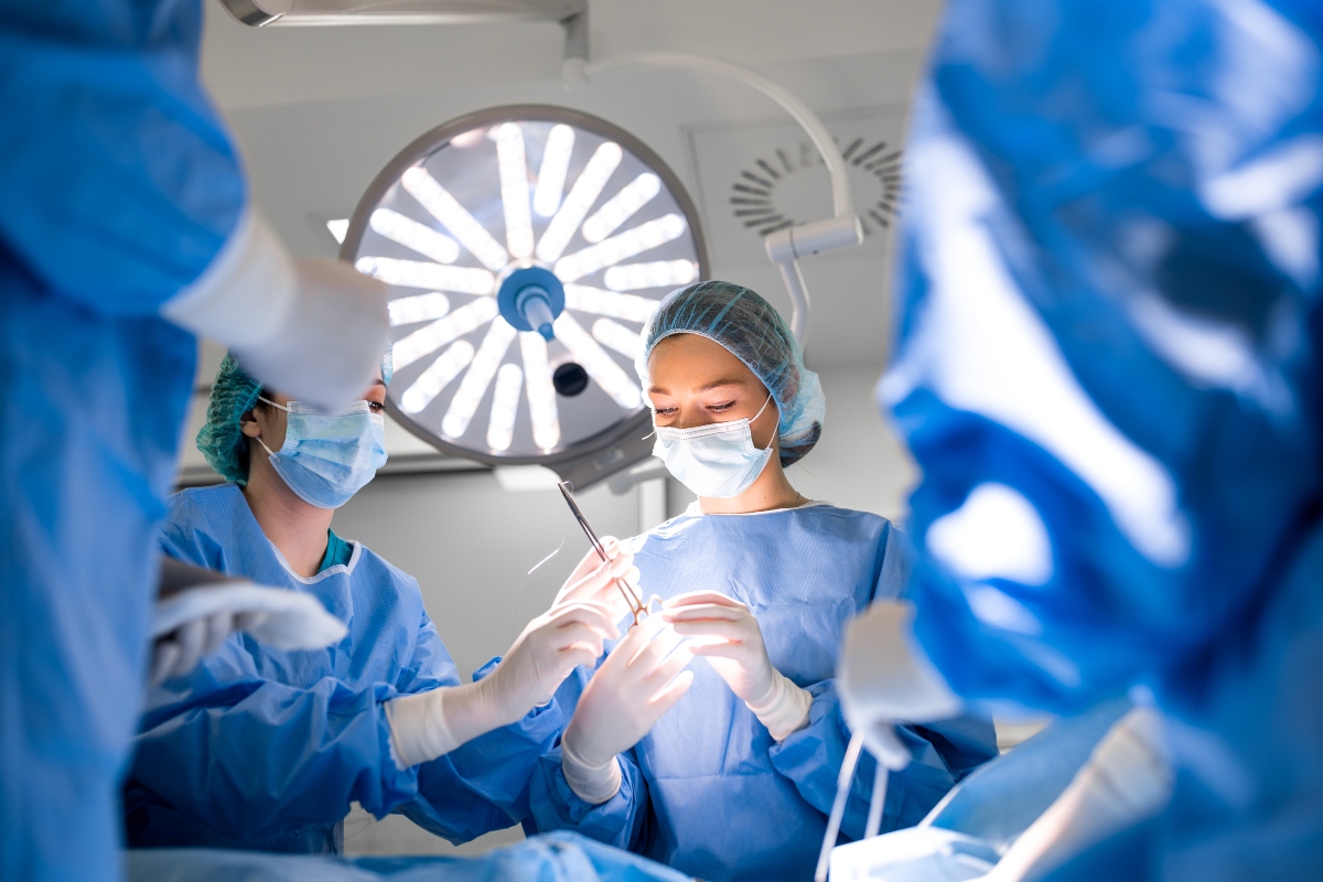 A team of professional doctors performing operation in a bright and modern operating theatre to illustrate the finding that broad-spectrum antibiotics are superior in preventing colorectal surgical site infections