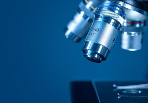 Closeup of a modern microscope on a dark blue background