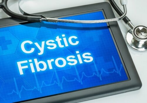 A tablet device with the words cystic fibrosis in white on a blue background and a stethoscope over the top to illustrate a Clinical Excellence in Respiratory Care session on cystic fibrosis after CFTR modulators and the evolution of adult services