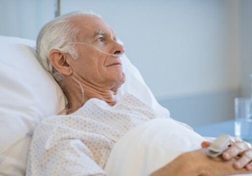 Old man laying in a hospital bed to illustrate that geriatric syndromes