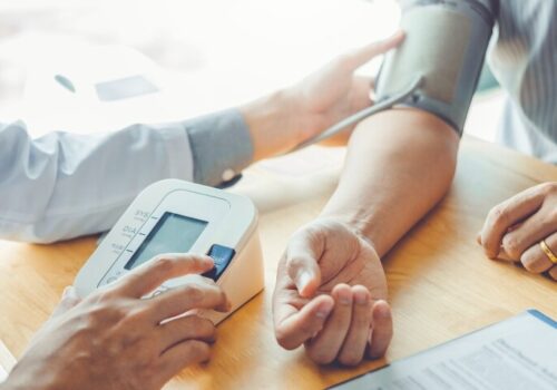 A close up of a doctor taking the blood pressure of a patient to illustrate hypertension progress stalling