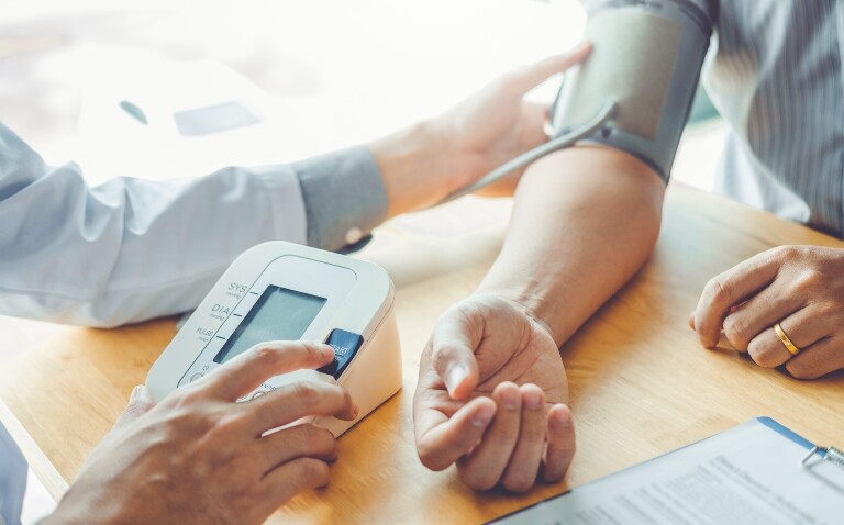 A close up of a doctor taking the blood pressure of a patient to illustrate hypertension progress stalling