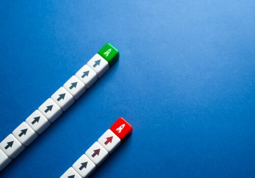 Two parallel lines of arrow-marked blocks on a blue background, one ending in a green block and the other in a red block with rocket icons, symbolising different performance outcomes for dupilumab versus tralokinumab in atopic dermatitis