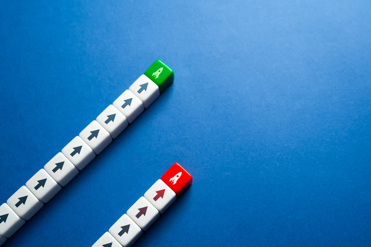 Two parallel lines of arrow-marked blocks on a blue background, one ending in a green block and the other in a red block with rocket icons, symbolising different performance outcomes for dupilumab versus tralokinumab in atopic dermatitis
