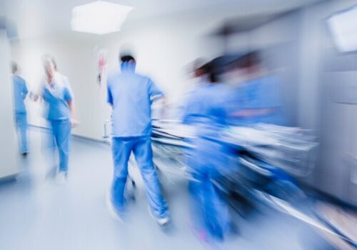 A blurred image of a medical team rushing a patient through an emergency department on a bed to illustrate a new catecholamine-sparing strategy for septic shock