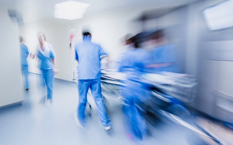 A blurred image of a medical team rushing a patient through an emergency department on a bed to illustrate a new catecholamine-sparing strategy for septic shock