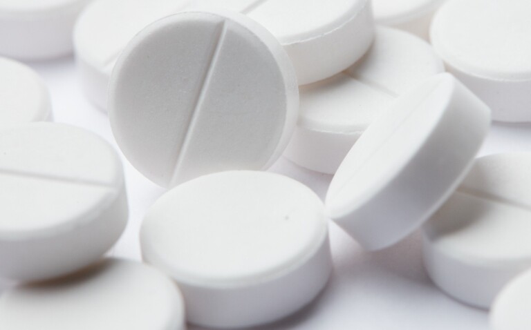A close up on a collection of white pills to illustrate low-dose aspirin use in older adults being linked to higher cancer mortality with no reduction in 10-year incidence