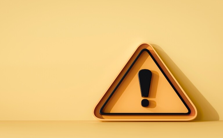 A yellow triangle with a black outline and a black exclamation mark in the centre on a yellow background to illustrate a new pharmacy safety campaign for HMPs