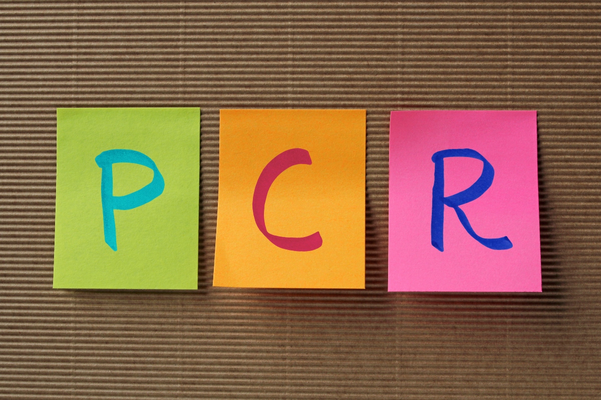 Green, orange and pink post-it notes in a row with a letter from PCR on each of them in blue, pink and dark blue to illustrate rapid diagnostics