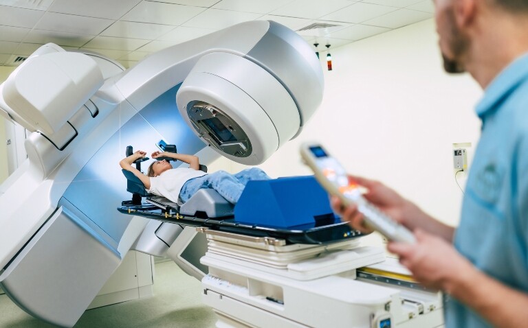 A woman receiving cancer treatment with a linear accelerator to illustrate new data supporting the safety of stereotactic radiotherapy with newer biological cancer therapies