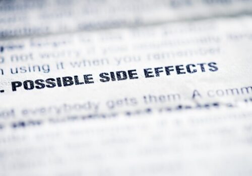 Close-up on the words 'Possible side effects' on a patient information leaflet to illustrate the suggestion that statins health information revisions are required after a study found limited side effect causation