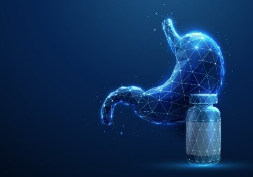 Abstract blue human stomach next to a medicine bottle to illustrate the finding that long-term PPI use may not increase gastric cancer risk as previously thought