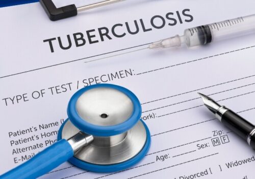 A close-up of a patient form on a clipboard with the title tuberculosis and a pen