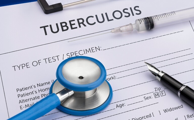 A close-up of a patient form on a clipboard with the title tuberculosis and a pen