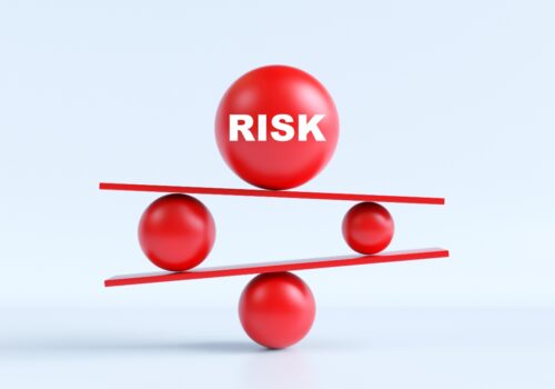 3D illustration of red spheres balancing on tilted platforms, with a large ball labelled ‘RISK’ on top to illustrate the finding that serious infection risk is broadly comparable across psoriasis therapies