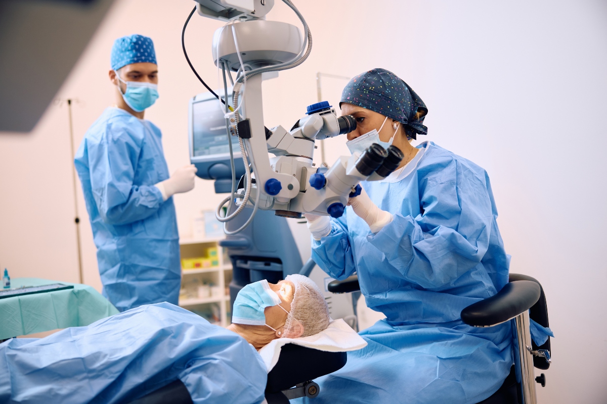A healthcare professional using a microscope while performing eye surgeryto illustrate uveal melanoma and encouraging registrations for an expert webinar about the disease