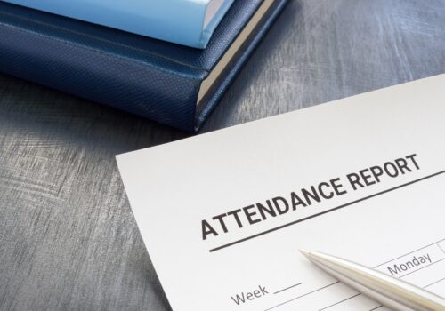 Attendance report form and a pen near notepad