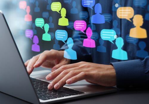 Person typing on a laptop with colorful digital icons of people and speech bubbles overlaid on the screen, representing online communication, patient feedback and virtual forum discussions to illustrate patient-reported barriers to implementing new asthma treatment guidelines