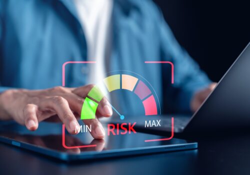 A man sitting at a laptop with a dial next to him going from green low risk to red high risk to illustrate a new risk calculator supporting ‘more rational resource allocation’ for weight loss interventions