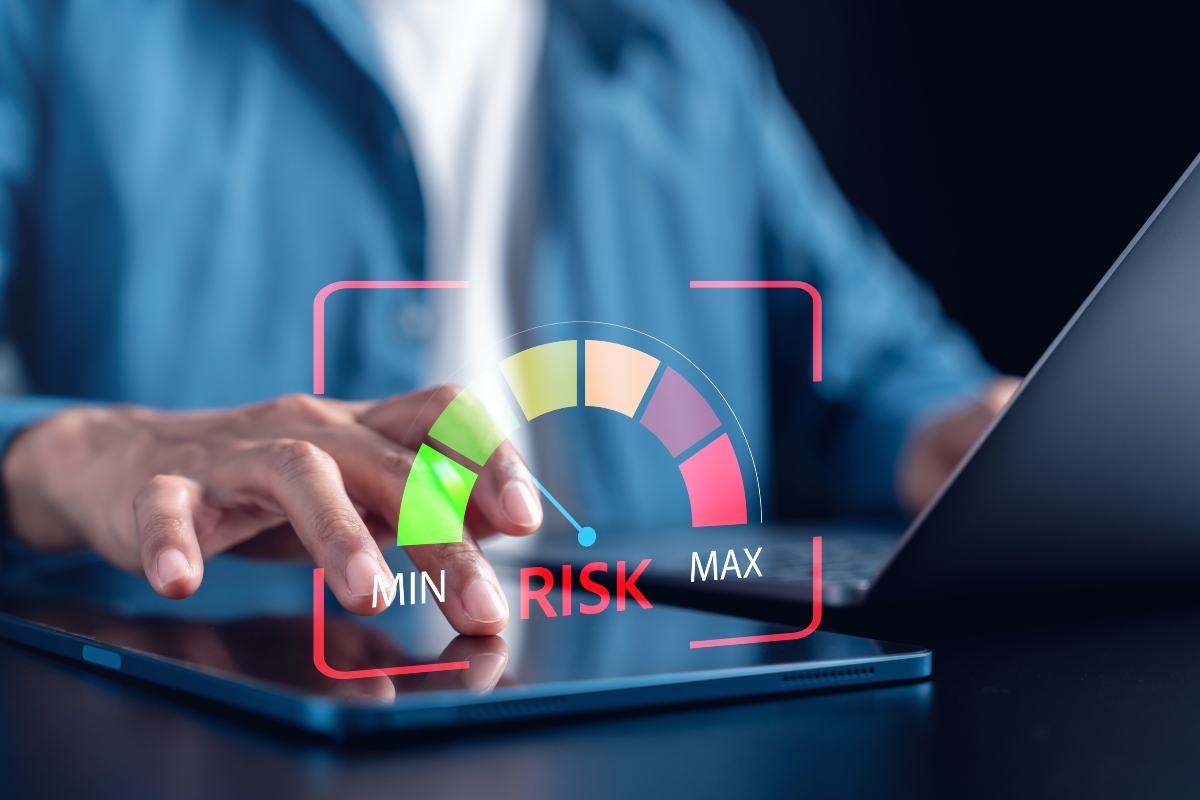 A man sitting at a laptop with a dial next to him going from green low risk to red high risk to illustrate a new risk calculator supporting ‘more rational resource allocation’ for weight loss interventions